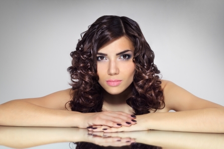 Portrait of a girl with beautiful hairstyle on gray backgroundの写真素材
