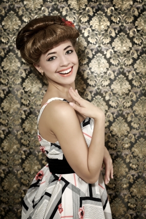 Smiling girl with retro hairstyle on dark backgroundの写真素材
