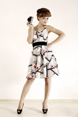 Pin up girl with retro camera on light backgroundの写真素材