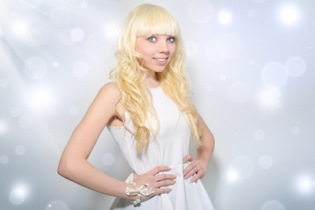 Beautiful girl with curly hair on a light backgroundの写真素材