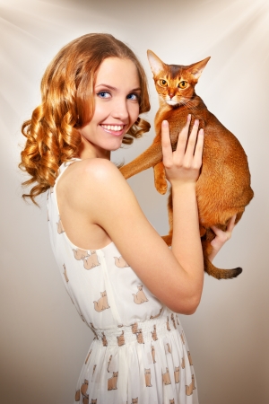 girl with Abyssinian cat on light backgroundの写真素材