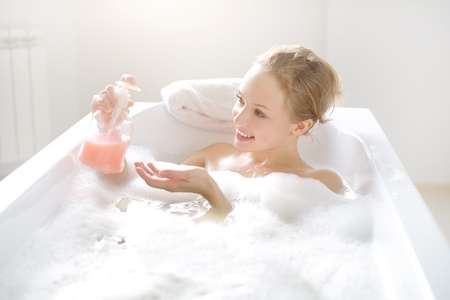 Girl with liquid soap in the bathの写真素材