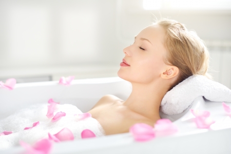 An Attractive girl relaxing in bath on light backgroundの写真素材