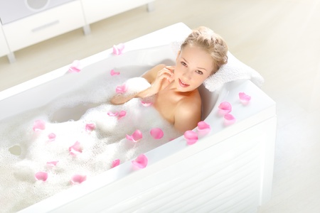 An Attractive girl relaxing in bath on light backgroundの写真素材