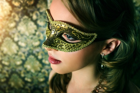 Beautiful girl in carnival mask on dark backgroundの写真素材