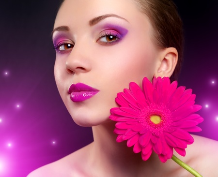 Girl with gerbera flower on purple backgroundの写真素材