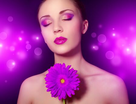 Girl with gerbera flower on purple backgroundの写真素材