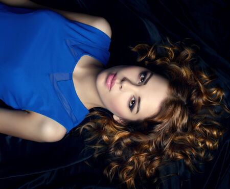 Pretty girl with short curly hair  dark backgroundの写真素材