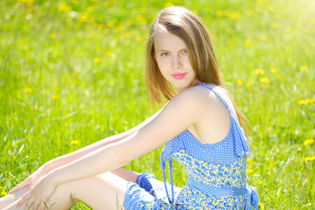 Smiling girl lying on the grass. light backgroundの写真素材