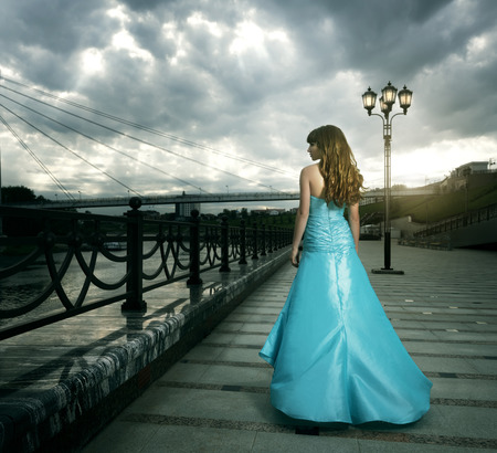 Attractive girl in long evening dress. black backgroundの写真素材