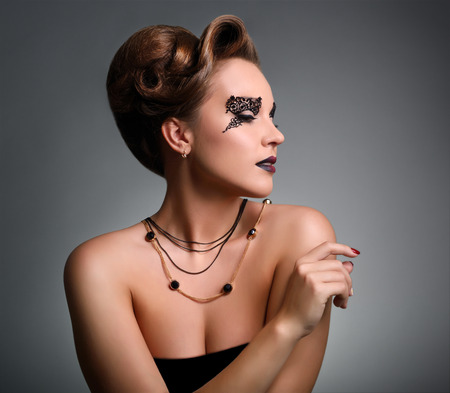 Attractive girl with beautiful makeup on gray backgroundの写真素材