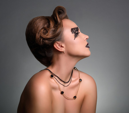 Attractive girl with beautiful makeup on gray backgroundの写真素材