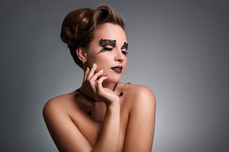 Attractive girl with beautiful makeup on gray backgroundの写真素材