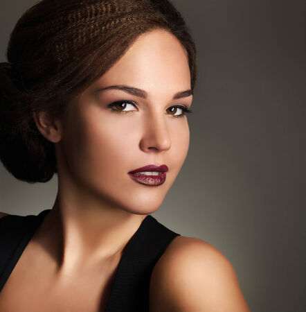 Young woman with beautiful makeup and retro hairstyle on gray backgroundの写真素材