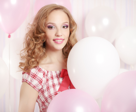 Girl with balloons on light backgroundの写真素材