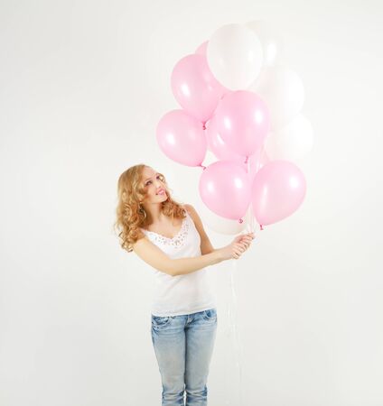 Girl with balloons on light backgroundの写真素材