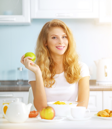 An attractive girl with a green apple. Healthy breakfastの写真素材
