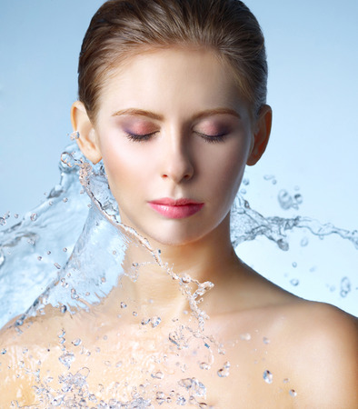 Beautiful girl and stream of water on blue backgroundの写真素材