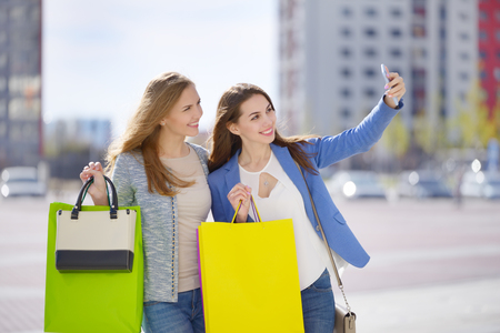 Two stylish girls with shopping bags. Outdoorsの写真素材