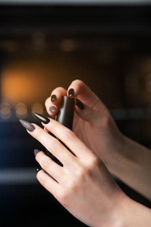 Nail polish. Woman hands with beautiful black manicureの写真素材