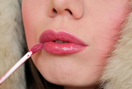 close-up of girl's lips who applying  lip-glossの写真素材