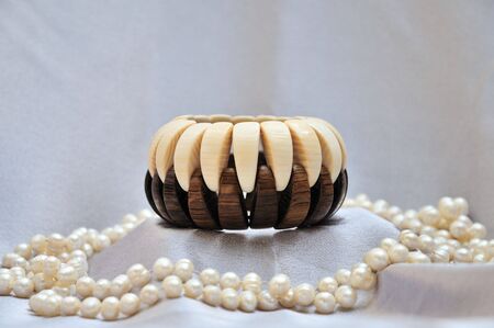 wooden bracelet with pearls on grey silkの写真素材
