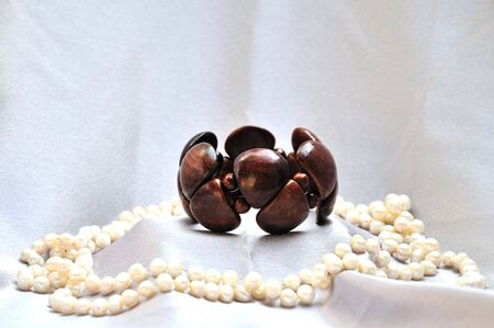 wooden bracelet with pearls on grey silkの写真素材