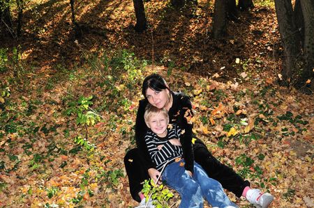 boy embracing his mother in the forest の写真素材