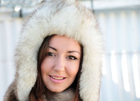 Pretty brunette with hazel eyes is wearing winter fur cap の写真素材