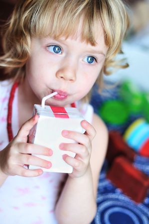  little lovely girl drinking juice from strawの写真素材