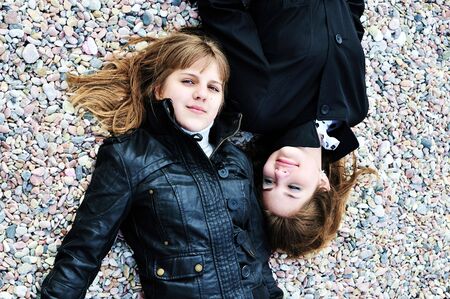 two lovely teen girls laying on the pebble in spring timeの写真素材