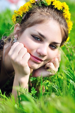 spring dandelion face of teen girl who laying in grassの写真素材