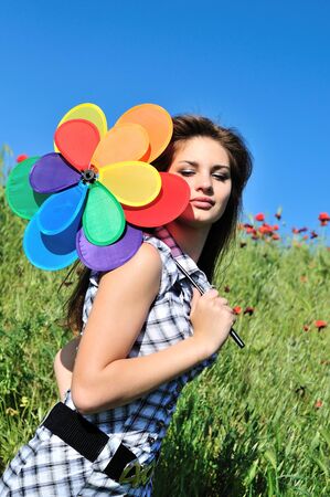 girl and windmill sitting in the grass over the blue skyの写真素材