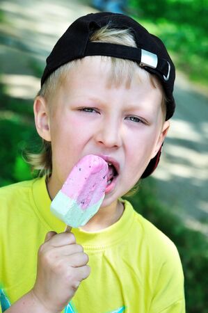funny little boy eating tasty ice-creamの写真素材