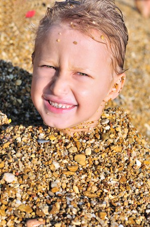 funny boy on the beach in sand の写真素材