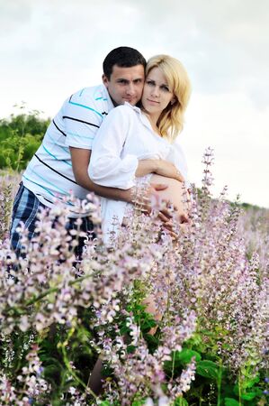 future happy parents standing in the summer fieldの写真素材