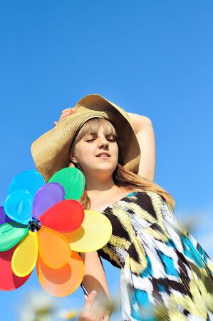 girl with windmill over the blue clear skyの写真素材