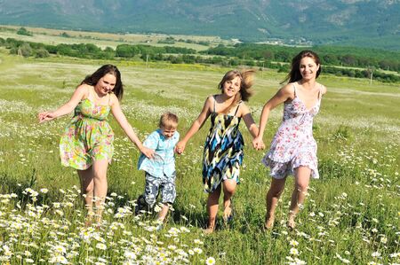 happy child and teens running in the daisy field の写真素材