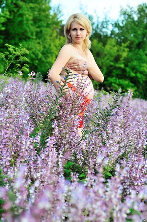beauty blonde pregnant woman at one with nature with red belt on the bellyの写真素材
