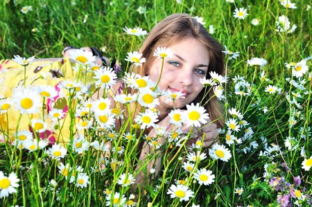 tender girl in daisy flowers on meadow の写真素材