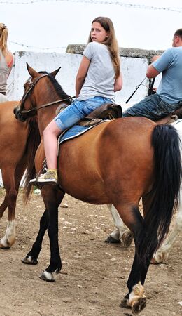 teen longhaired girl sitting on the horse の写真素材