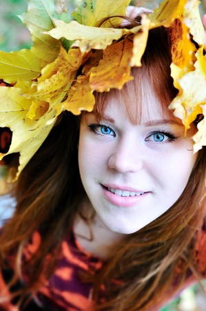 autumn redheaded gril with crown from leavesの写真素材
