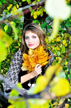 beautiful teen girl sitting in the autumn forestの写真素材