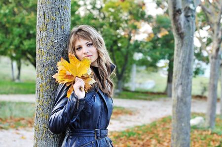 teen girl near autumn tree in the parkの写真素材