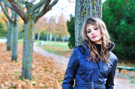 sad teen girl in the autumn parkの写真素材