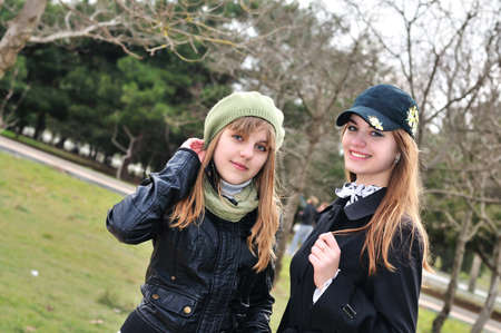 Two teenage girls walking outdoors in parkの写真素材