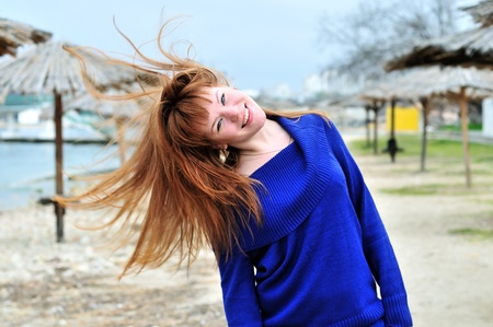 redheaded happy girl having fun with her hairの写真素材