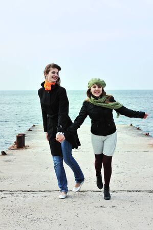 two happy running  teen girls near the seaの写真素材