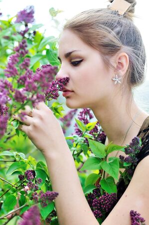 tender young girl smelling lilacの写真素材