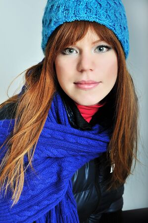 redheaded winter girl wearing blue scarf and hatの写真素材